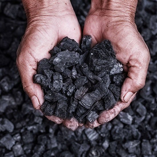 A man holding coal in his hands
